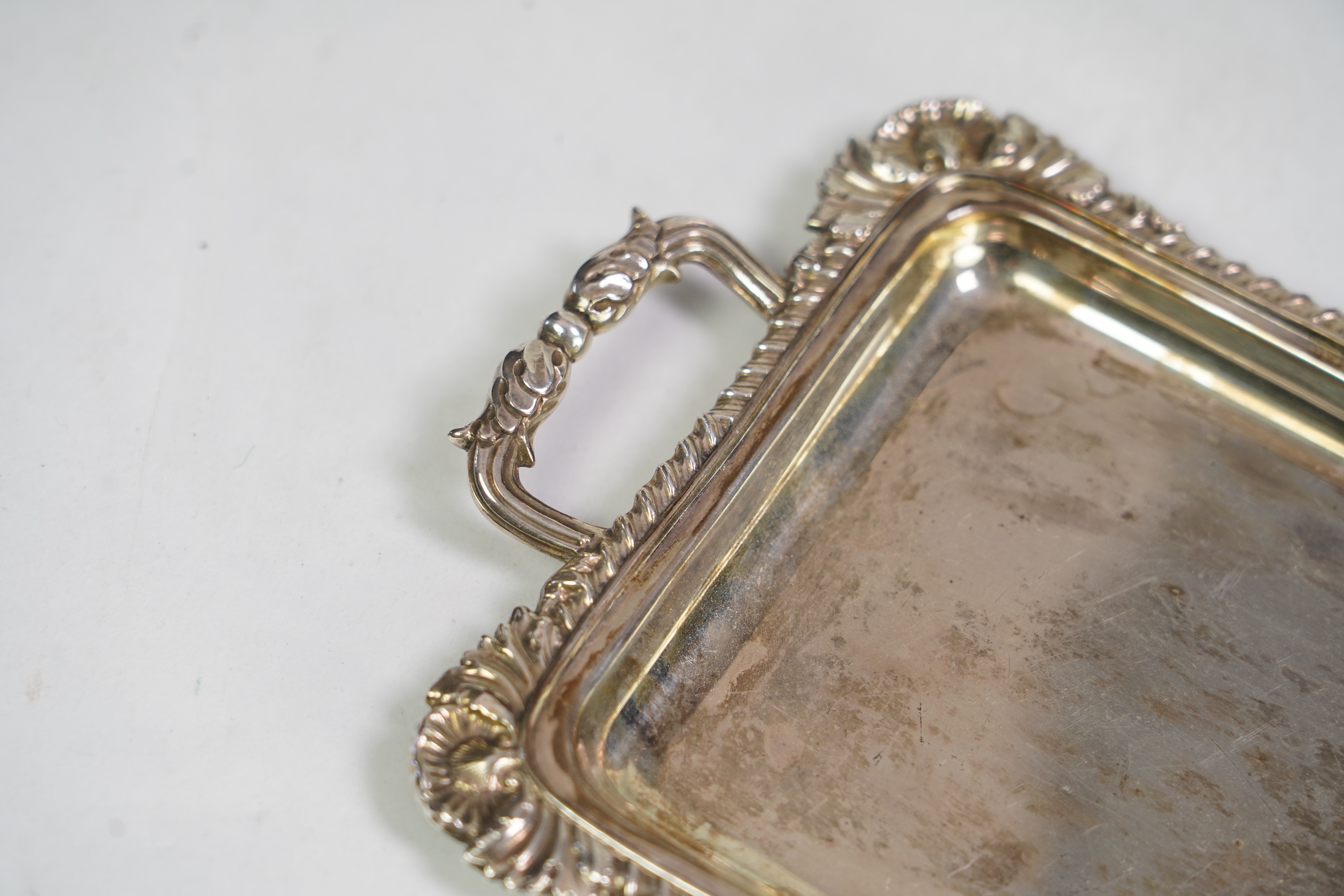 An Edwardian cased silver small two handled serving tray with six matching silver mounted glass liqueur tots, by Atkin Brothers